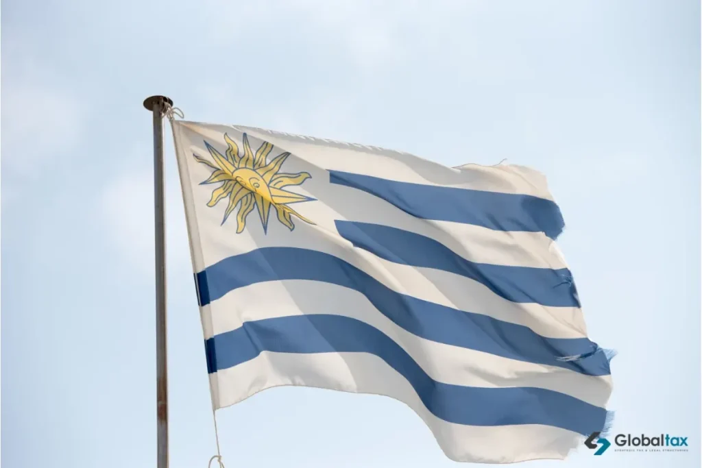 Bandera uruguaya con el Sol de Mayo flameando contra un cielo claro